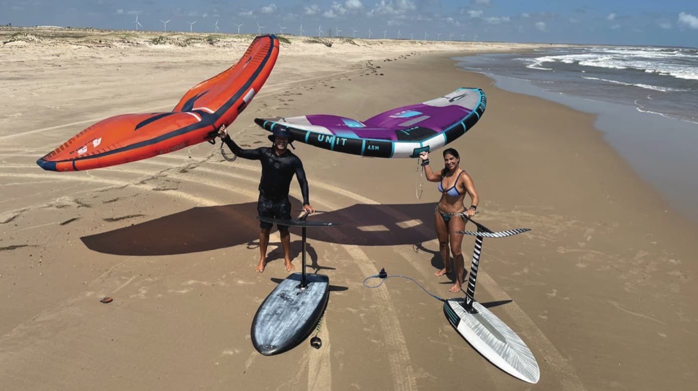 Two riders with wings and foil boards on a Brazilian beach