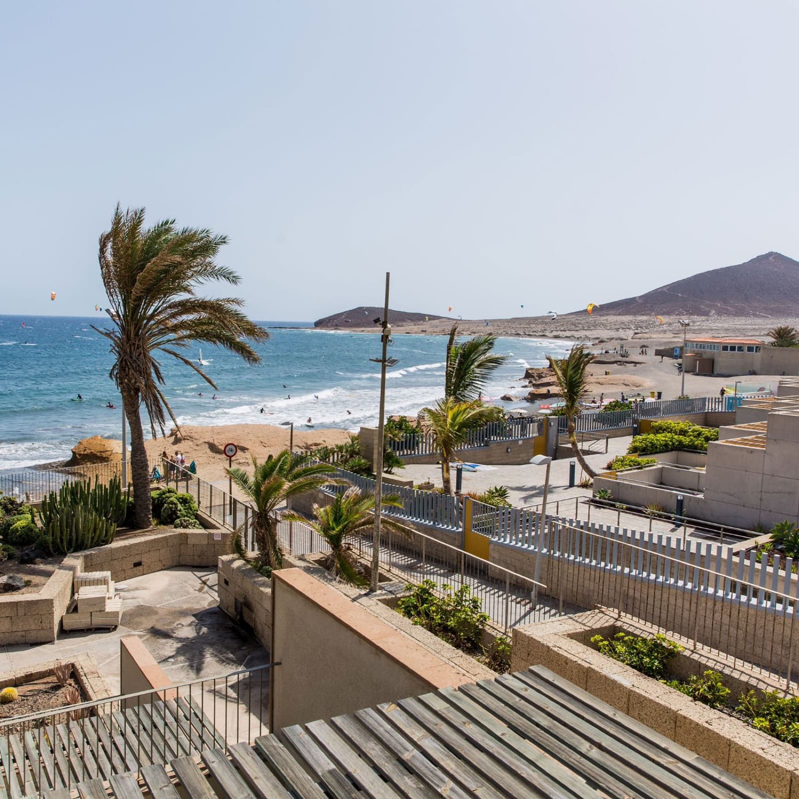 The promenade and beach at El Médano with kites on the water