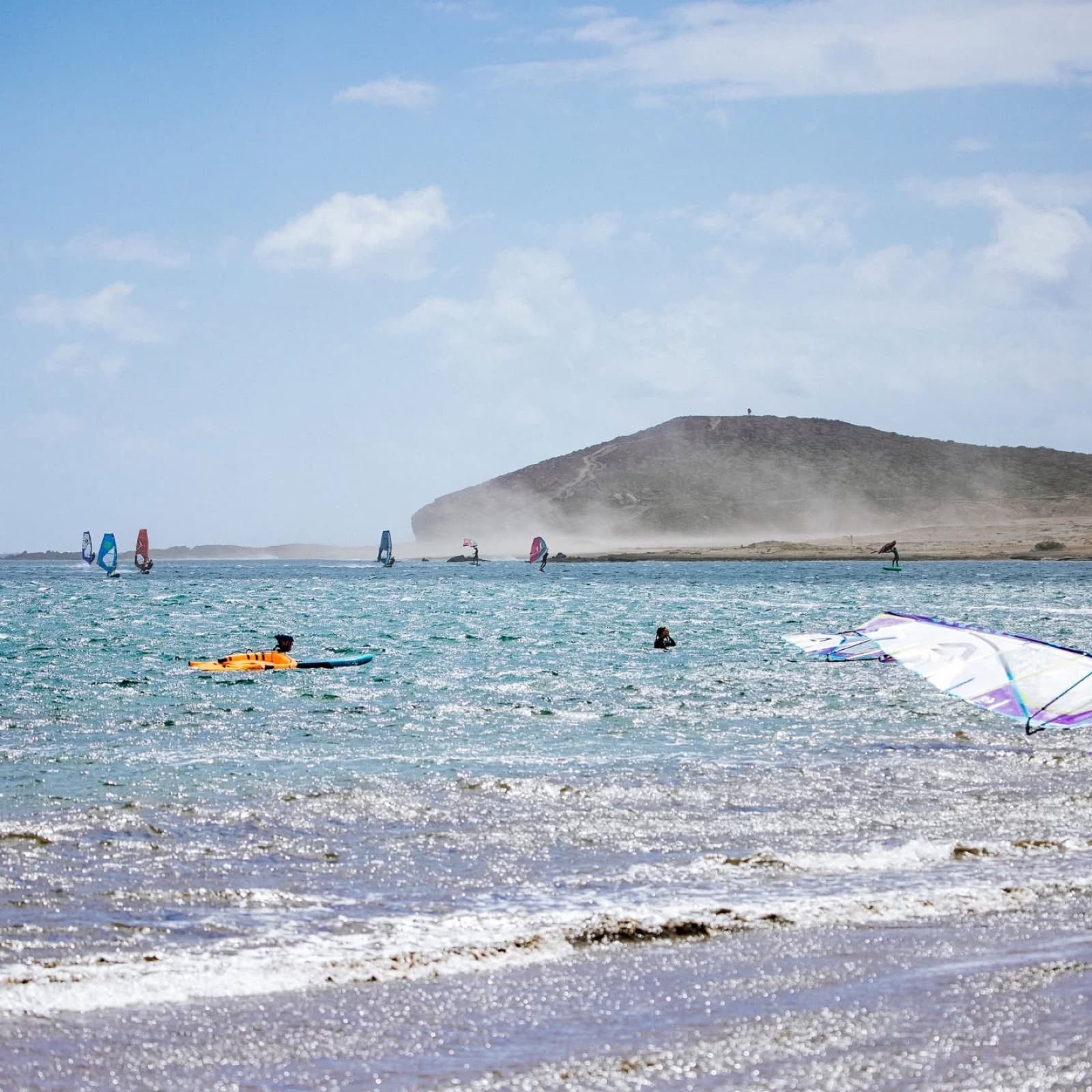 Windsurfers and wing foilers in the bay at El Médano under Montaña Roja