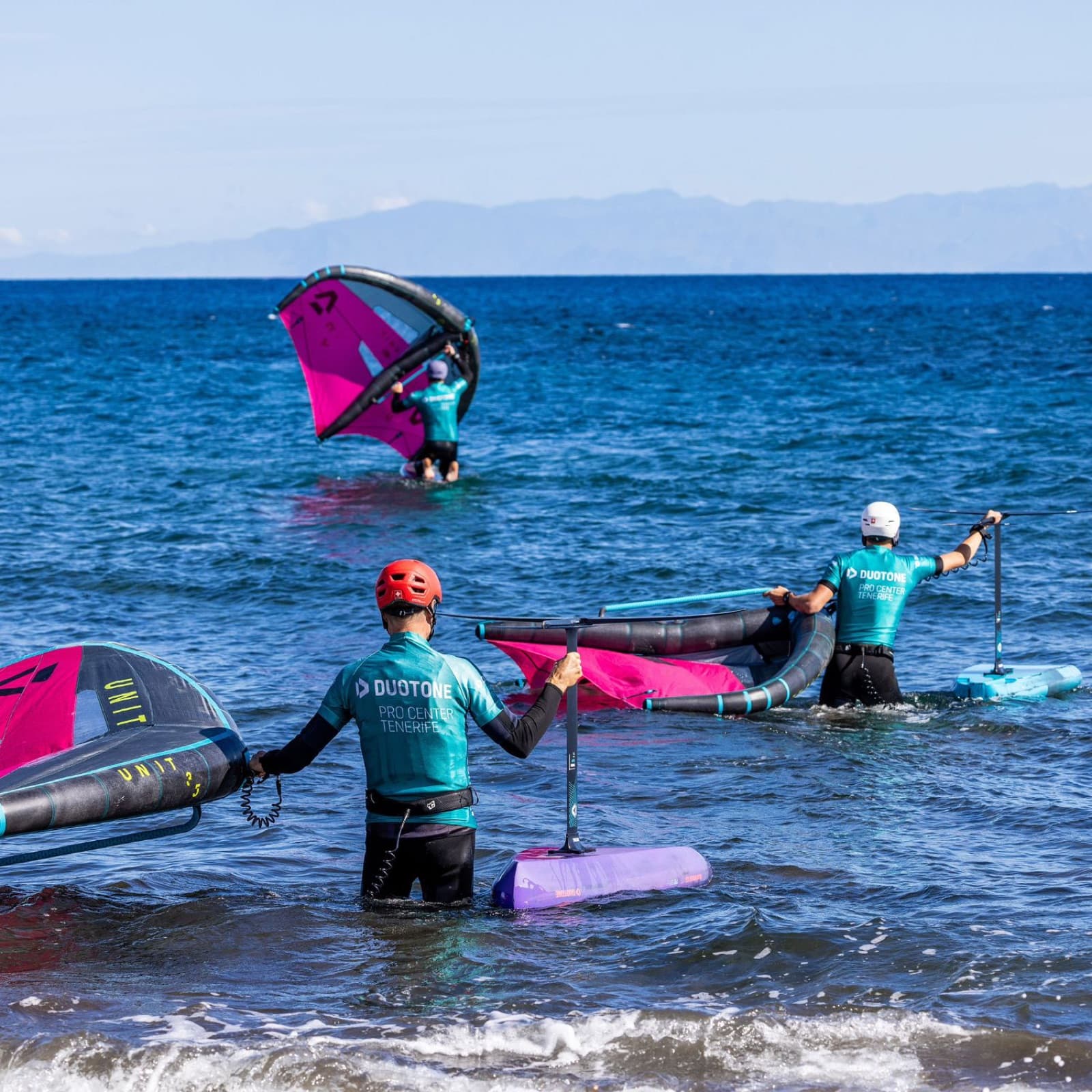 Wing foilers walking out from the beach at Duotone Pro Center Tenerife
