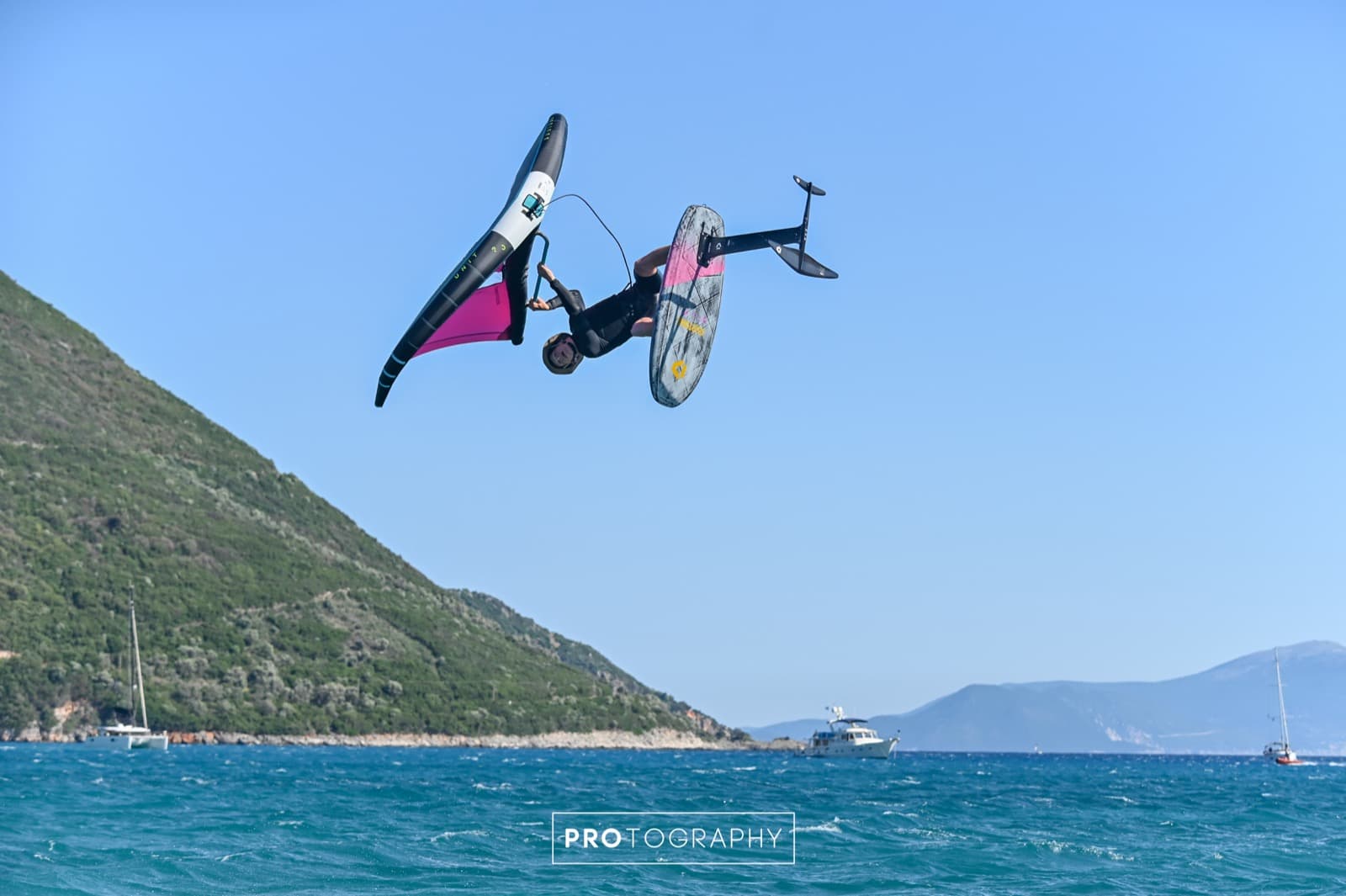 Toby mid-air under the mountains of Vassiliki