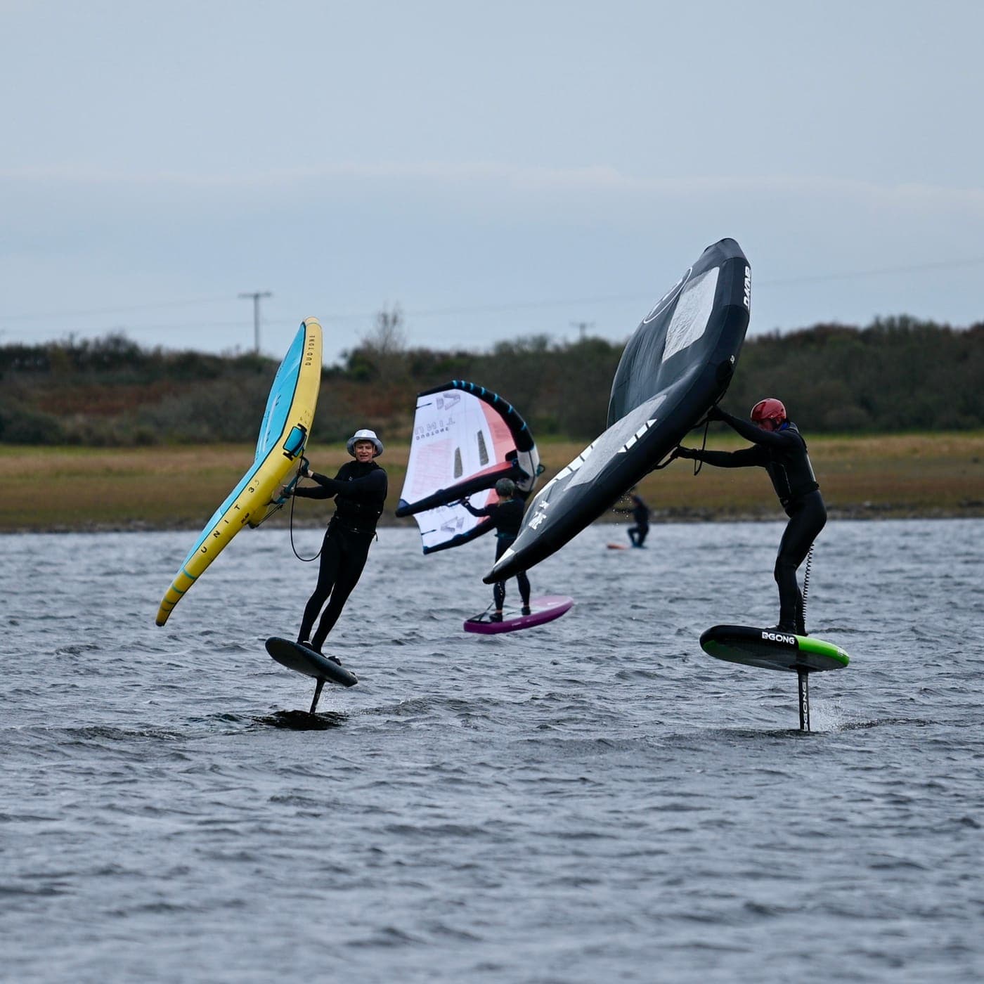 Three riders foiling together on Stithians Lake